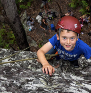 a kid enjoying climbing the rock face of a rock. Outdoor Raw climbing caters for all ages and times. Located a short drive from Culburra Beach on the South Coast NSW.