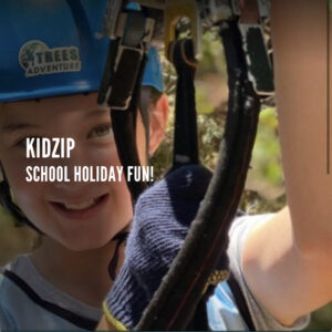 A kid all harnessed up on a zip line ready to go tree-top climbing. The Tree Adventure group run many at many different times. Located not to far from Culburra Beach on the South Coast NSW.
