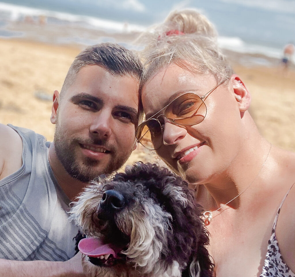 Culburra Beach on the South Coast NSW is well known for being dog and pet-friendly. A young couple with their dog enjoying some time at Culburra Beach.